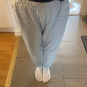 Grå mjukisbyxor! - Säljer ett par gråa nästan  baggy byxor! Jättefina och nästan helt nya! Använt väldigt få gånger💕💕 Säljer då dem inte kommer till användning💞💞 Dem är inte lika tajta nere vid benen,ser så ut för att dem är för små för mig💕 