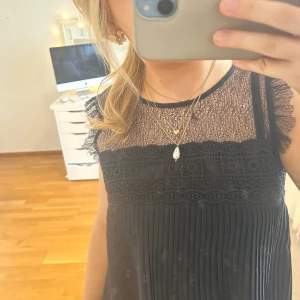 Blus!! - Svart blus med spets detaljer högst upp! Blusen är avklippt längst ner för att den var väldigt lång innan men annars är den i nyskick❣️obs spegeln som är dammig, tröjan är inte fläckig!! Skickar inga fler bilder❣️😇passar xs-s