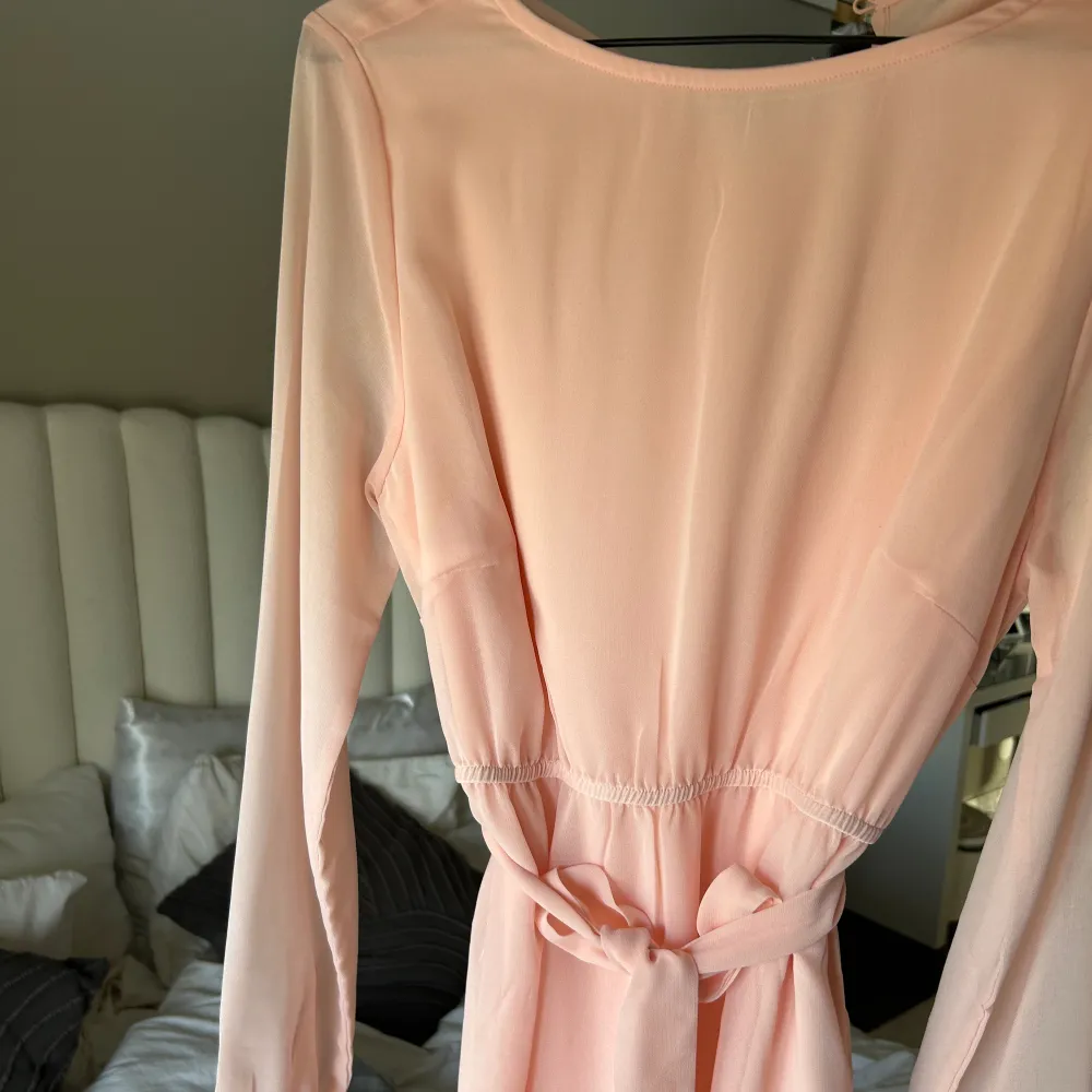 Rosa klänning som är perfekt nu till sommarn! Den har ett band i midjan som man knyta antingen i fram elelr bak! Lite genomskinligt material vid ärmarna!. Klänningar.