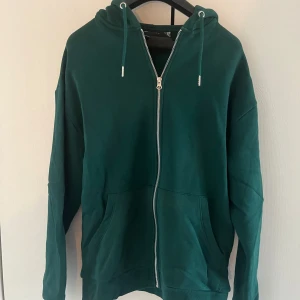 Grön helzipad hoodie från asos - En jätteskön zip hoodie från asos sitter tajtare i armarna och bredare i midjan. Den är oversized storlek xs men skulle lätt passa s/m