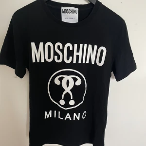 Moschino t-shirt - Nu säljer vi en riktigt fet T-shirt från Moschino för 299kr. Storlek: S, Skick: 7,5/10