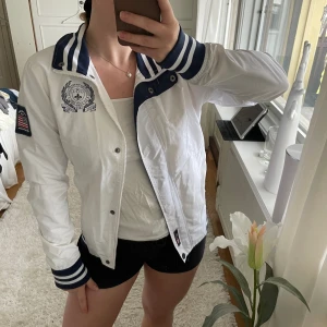 Jacka - Seglarjacka från US Polo Assn säljes. Har en liten reva i tyget på ena armen och någon svart ”fläck” (se bilder). Vet ej om det går bort i tvätten. Superfin och skön som är vind och vattenavvisande.