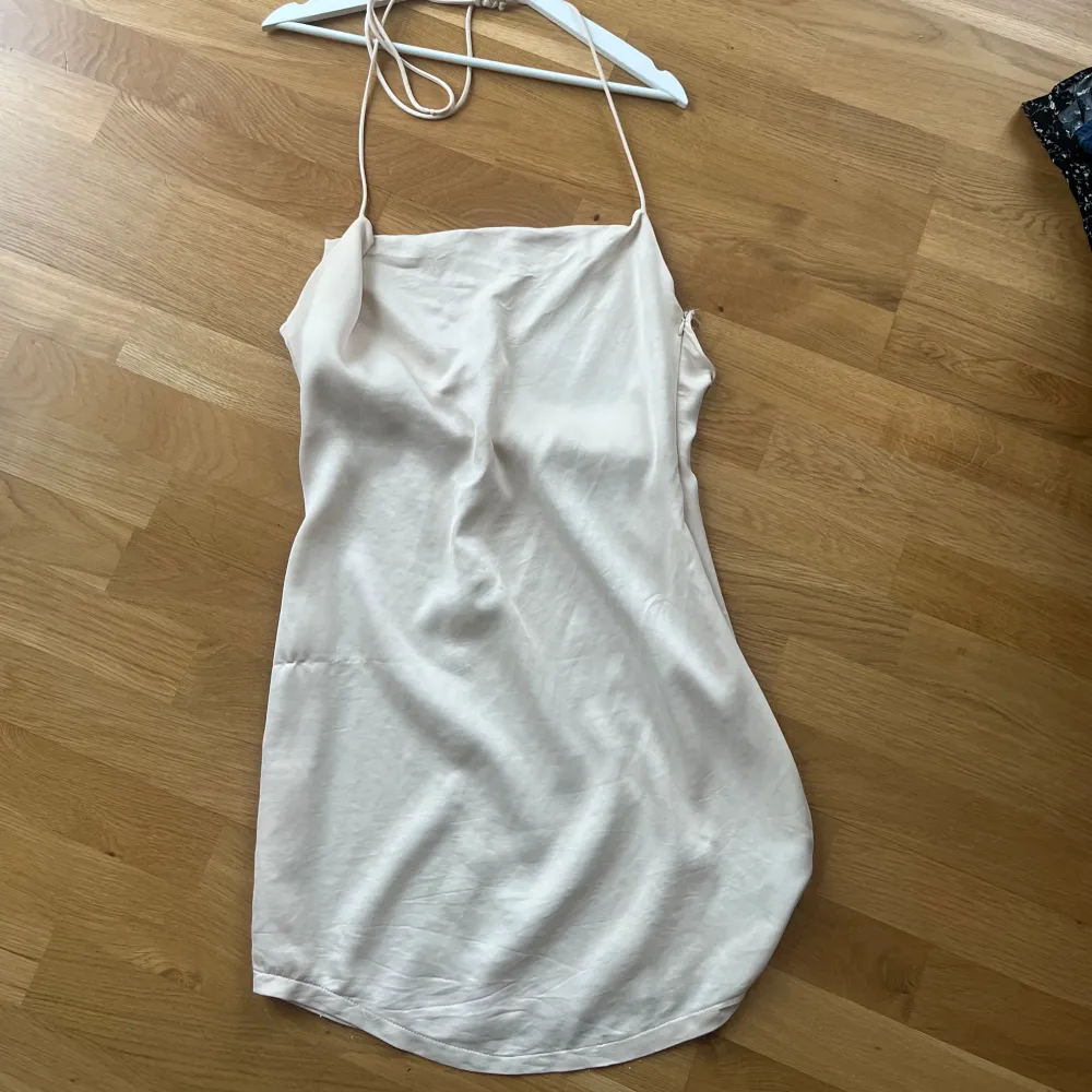 Säljer denna snygga klänning i Champange färg från Nakd. Storlek 40. Har även öppen rygg med knytning som man kan dra åt vilket gör att den går att få lite tajtare🌼 köp via ”köp nu”💗. Klänningar.