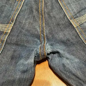 Fina nudie jeans med ett minimalist hål  vid skrevet