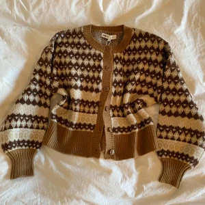 Oanvänd  mönstrad kofta - Supermysig mönstrad kofta, aldrig använd. Passar så fint över en sommarklänning nu till våren!  Köpt för 450kr.