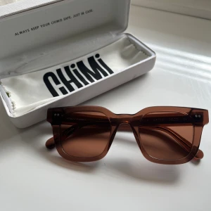 Chimi #004 Coco - Lätt använda Chimis i modellen 004 utan repor. Det är den gamla modellen i färgen Coco som är en jättefin brun färg. Den ena bågen är lite lös men går att spänna åt skruvmejsel. Låda och servett medföljer med men lådan har lite skador. Nypris 1250