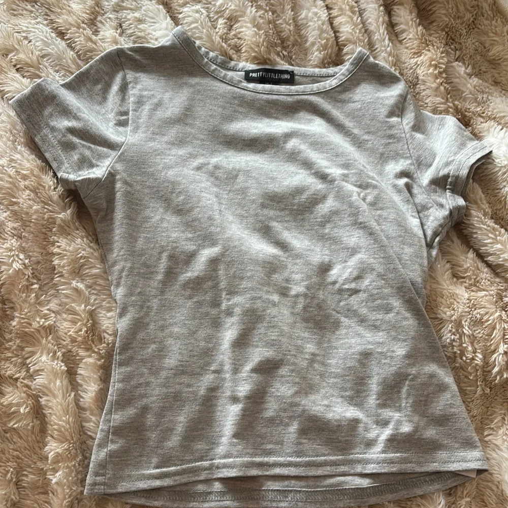 Pretty little thing tshirt i grå som formar fint i storlek xs . T-shirts.