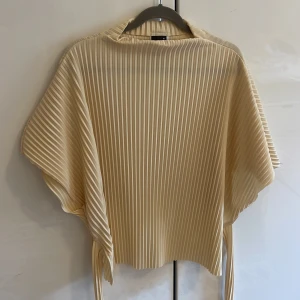 Fin topp - Plisserad benvit med lätt öppen rygg 