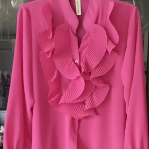 Cerise Blus - Fantastiskt fin blus i härligt cerise från märket New Collection. Obetydligt använd.