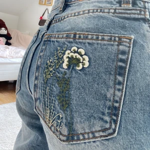 Söta baggy jeans med brodering av blommor  - Sånna söta jeans ju till våren och sommaren💕Köppt för ett tag sedan men knappt använda då det är för små🥰, sitter high/midrise skulle jag nog säga💓 Midjemått: 31 cm