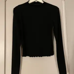Basic långärmad svart tröja med volanger på kanterna och vid kragen. Ett perfekt basic plagg att ha i garderoben😍väl använd men trots det i bra skick.