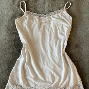 Vitt spetslinne  - Sött linne i fint skick utan skador. Det är stretchigt och slutar ungefär vid min höft. Köpt på vintage avdelningen på en second hand och fjärilsdetaljen har jag själv sytt på. Skriv privat om ni har frågor🤍