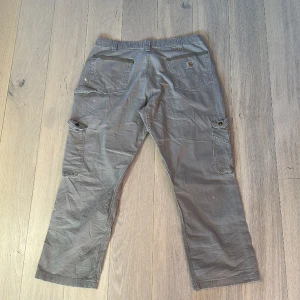 Carhartt cargo pants double knee - Carhartt cargo pants säljes i storlek 38x30. En del färgstänk som syns på andra bilden samt ett hål på ena fickan som inte har någon inverkan. Fler bilder kan ordnas! Fråga om du har frågor!