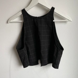 Rutig matchande kjol och topp - Lulu set från American Apparel. Svart, rutig minikjol och topp med öppen rygg. (Kan eventuellt vara liten i storleken)  Bra skick!! 