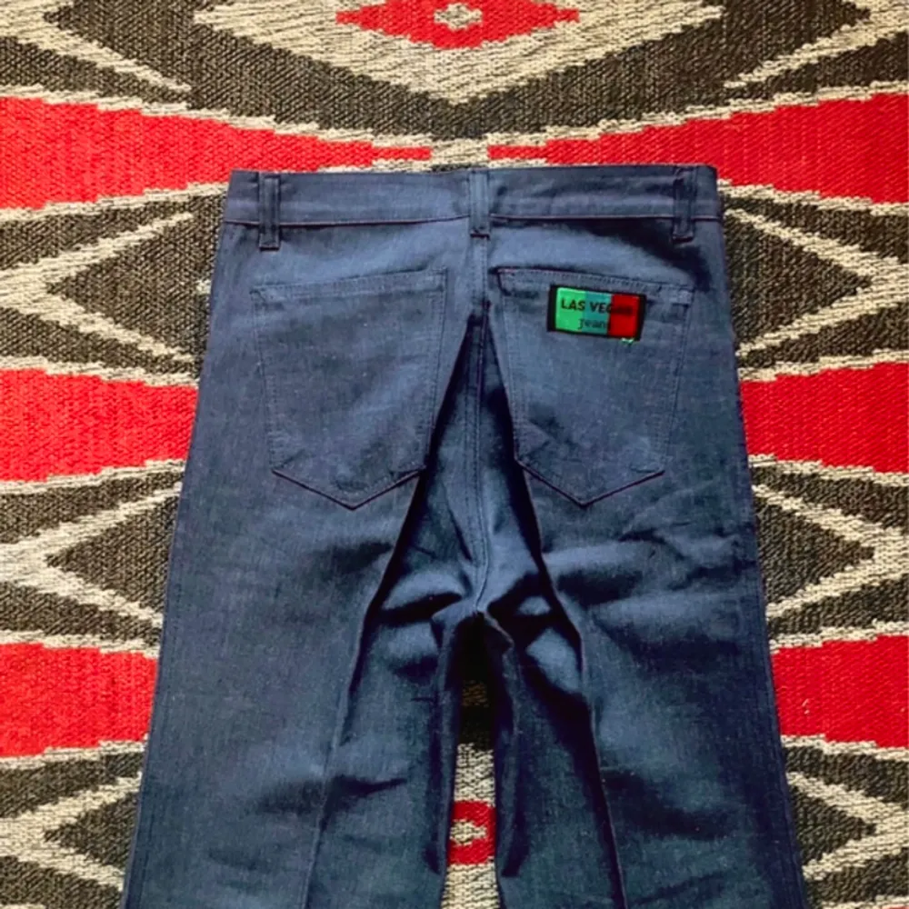Supercoola 70-tals jeans av märket Las Vegas skurna i tidsenslig siluett. Deadstock, ny gammal, aldrig använd vintage. Midja-35 Höft-41 Gren-28 Längd-116 Innerben-88 (cm). Rålängd, har ingen fåll på nederkanten. 100% bomull lätt denim. . Jeans & Byxor.