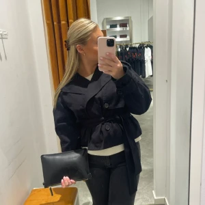 Trenchcoat  - Säljer denna svarta trenchcoat då den börjat bli för liten, köpt i sommars på Gina och inte använd mer än fem gånger Max, nypris 699 mitt pris 400