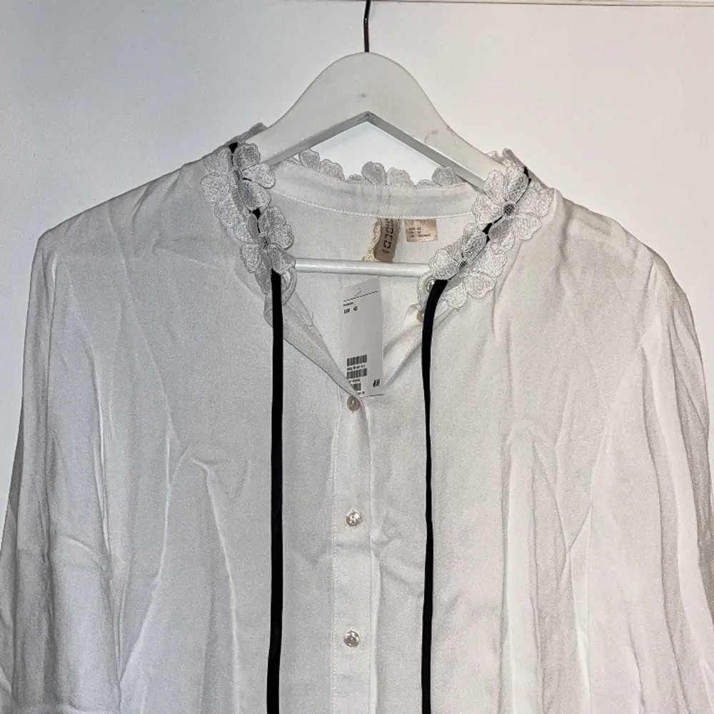 Snygg vit skjorta från hm med fina detaljer. Helt ny o oanvänd så lappen kvar . Blusar.