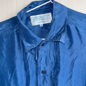 Kortärmad skjorta i 100% silke från Bisbee. Härlig djupblå färg.