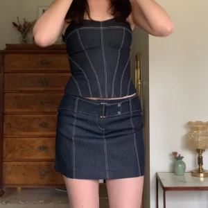 Vintage jeansset - Kjol + tubtopp i mörkt jeansmaterial och med ljusa sömdetaljer, från Karen Millen! Toppen är i korsettmodell med krokstängning i ryggen, och kjolen har ett inbyggt skärp (midjemått: 76, längd: 33) 💞 