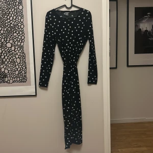 Prickig klänning  - Använd men i fint skick, storlek S från Lindex. Stretchig med struktur och skärp i midjan. 