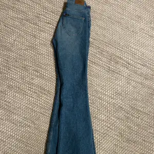 Blåa bootcut jeans från Lee, höga i midjan. Som nya, använda ca 2 gånger. Storlek W25L31 200kr