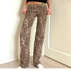 Ormmönster byxor - SUPER snygga jeans, lånade bilder❣️❣️kolla min andra anons för egna bilder❣️💞men exakt samma byxor. Midjemåttet när dem ligger ner:38, linnerbenslängd: 80❣️ helt slutsålda 💞