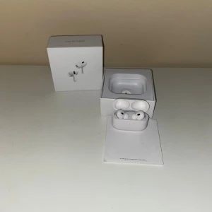 Begagnade AirPods Pro 2 ANC - Säljer ett par AirPods Pro med originalförpackning och laddningsetui. Hörlurarna är i bra skick. Aktiv brusreducering och trådlös laddning. Perfekt för musik, samtal och träning. Komplett med allt som syns på bilderna.