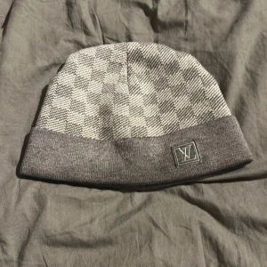 Grå Louis Vitton mössa - Snygg Louis Vitton mössa som säljs pga att jag inte använder den längre.har använts en vinter och är ett superbra plagg för vintern