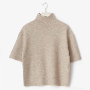 Beige stickad polotröja kort ärm - Supermysig beige stickad polotröja med korta ärmar och ribbad hög krage. Endast använd 2 ggr. 