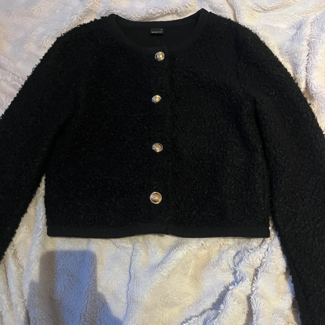 Svart kofta med guldknappar