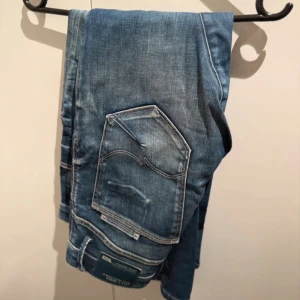 Blå jack and Jones Comfort Fit Mike jeans - Säljer ett par blå jack and Jones Comfort Fit Mike jeans med snyggt slitna detaljer och klassiska fem fickor. Jeansen har raka ben och normal passform, tillverkade i mjukt denimtyg för extra komfort. Perfekt för dig som gillar avslappnad stil.