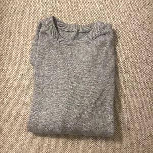 Grå stickad tröja  - En enkel och stilren grå stickad tröja med rund halsringning och ribbade muddar vid ärmslut och nederkant. Perfekt att matcha med jeans eller chinos för en clean look. Märke: vet jag inte då de har gått bort. Men en väldigt basic men snygg grå stickad tröja. När den väl kom till användning så var de en bra passform enligt mig men säljer då den tyvärr är för liten. Jag skulle säga att den passar någon vid ca 150 cm. Hör gärna av er om ni vill ha en bild på hur tröjan sitter på:)