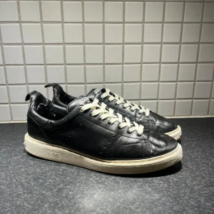  Golden Goose skor - Tja just nu säljer jag mina Golden Goose sneakers i svart skinn med vit platt sula och vita snören. Klassisk starter moddel med stjärndetalj under sulan. Kommer med original dustbag. Snygg minimalistisk look som funkar till jeans och hoodie. har även ett kvitto eller är du sugen på att byta mot något så är det bara att höra av dig med vänliga hälsningar Oscar 
