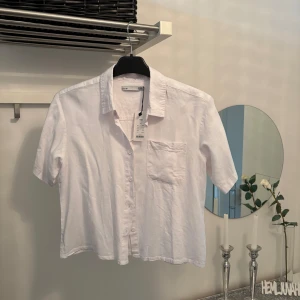 Vit kortärmad skjorta från Lager 157. - Fräsch vit skjorta från Lager 157 med korta ärmar, klassisk krage och bröstficka. Skjortan är i luftig bomull och har knäppning framtill. Perfekt för en clean och stilren look.