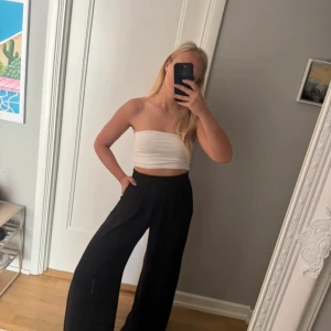 Svarta utsvängda byxor - Säljer ett par svarta byxor från ZARA i storlek S. Byxorna har hög midja med resår, breda ben och en skön, flowy passform. Super poupulära och har fickor på sidorna.