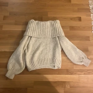 Beige stickad offshoulder-tröja Gina Tricot - Supermysig beige stickad tröja från Gina Tricot i storlek S. Tröjan har bred ribbad offshoulder-krage och ballongärmar med ribbade muddar. 💕💕