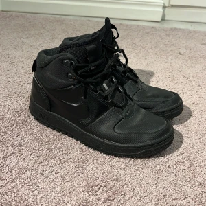  Nike Air Force 1 Highs  storlek 41 - Säljer ett par helsvarta Nike Air Force 1 Highs med snörning och platt sula. Skorna är perfekt inför vintern och väldigt varma inuti materialet står imot snö så perfekt för någon som är ute mycket  det är storlek 41 och har bara haft de 1 år själv klart finns lite slitars genom att jag använt dem själva innan skriv om ni vill ha mer info MVH 