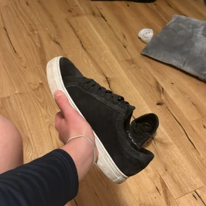 Marin blåa vagabond  - Säljer ett par stilrena marin blåa  sneakers i mocka med klassisk vit platt sula. Skorna har rund tå och snörning framtill, vilket ger en clean och modern look. Perfekta för dig som gillar minimalistisk stil och vill ha ett par snygga skor till vardags.