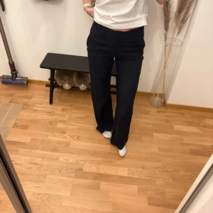 Kostymbyxor från Zara - Jättesnygga kostymbyxor från Zara. Marinblåa med ränder (ser mest marinblåa ut), vilket syns på bilderna. De är hål i fickorna och en knapp vid hylsan har trillat av, men detta syns inte när man har de på sig och man tänker själv inte på det. Fint skick annars! Sliten detalj vid midjan