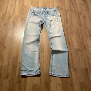 Ljusblå jeans från Camp David - Säljer ett par ljusblå jeans från Camp David med coola kontrastsömmar i blått och rött. Byxorna har raka ben, klassiska fem fickor och detaljerade broderier samt patch med flaggor och logga bak. Perfekt för dig som gillar unik stil och snygga detaljer. W33  Bilder på måtten finns tillgängliga. Fråga gärna! Snabb leverans!