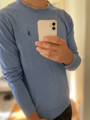 Blå tröja från Polo Ralph Lauren - Säljer en blå långärmad tröja från Polo Ralph Lauren i slim fit. Tröjan är gjord av mjuk pima bomull och har den klassiska broderade loggan på bröstet. Enkel och stilren modell med rund hals och ribbade muddar. Har du frågor eller funderingar är det bara att höra av sig. Priset är inte hugget i sten heller😀