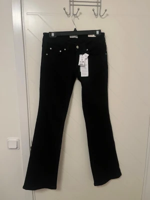 Svarta bootcut jeans från Gina Tricot - Svarta Y2K-inspirerade bootcut jeans från Gina Tricot med låg midja. Storlek 38! Fick i julklapp men tyvärr är det inte min storlek. Nypris är 499 kr men säljer de för endast 299 kr då dom är helt nya. På hemsidan är de slutsålda. 