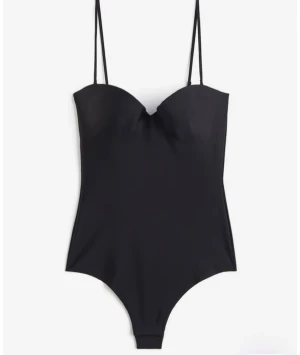 Svart bandeau med smala axelband - Snygg svart bandeau body med smala axelband och formad kupa. Bara använd en gång. Den har mikrofiber och är slutsåld på h&m. Strl 75B