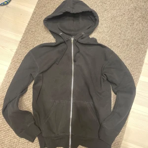 Hoodie | H&M. - Säljer en svart hoodie med dragkedja från H&M. Knappt använd. Kanske ser grå ut på bilden men är helsvart. Hoodien är i relaxed fit.
