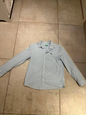 Randig skjorta - Säljer en randig skjorta från united of benetton. Storlek 160. Perfekt till lite finare tillfällen. Hör av dig om du har några funderingar.
