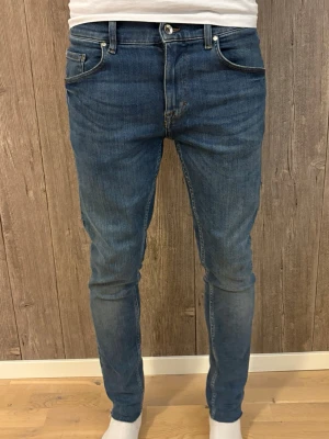 Tiger of Sweden Slim Fit Jeans – W30 L32 - Stilrena slim fit-jeans från Tiger of Sweden. Klassisk blå denim med snygg passform. Sköna och i bra skick.  ✔️ Storlek: W30 L32 ✔️ Passform: Slim fit ✔️ Färg: Blå denim ✔️ Skick: Mycket Bra