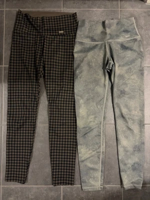 Två par mönstrade tights från aim’n - Säljer två par tights, ett par med klassiskt rutigt mönster i svart och brun samt ett par med grönt camouflageinspirerat mönster. Båda har hög midja och är tillverkade i mycket stretchigt material