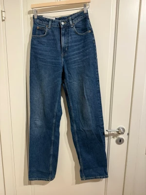 Baggy jeans  - Blåa jeans i 90s baggy modell. Midjan är hyfsat hög.