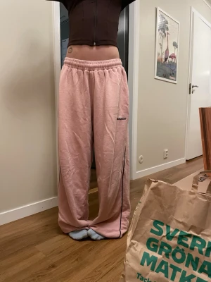 Rosa mjukisbyxor/träningsbyxor från iets Frans XS - ‼️PRIS GÅR ATT DISKUTERA ‼️               Säljer ett par ljusrosa mjukisbyxor från iets Frans i storlek XS. Byxorna har baggy passform och går att dra åt i midjan och längst ner vid foten. De har en bakficka och broderad logga på framsidan. Materialet är mjukt bomullstyg, perfekt för dans eller för att mysa hemma eller gå på stan, funkar alltså till allt!! Jag har haft dem i ett halvår men det är ingen skada på dem!!
