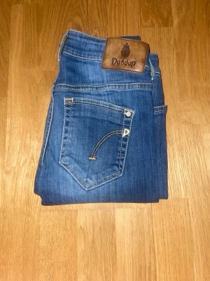 Blå jeans från Dondup - Snygga blå jeans från Dondup med klassisk femficksdesign och brunt läderpatch bak i midjan. . Perfekta för dig som gillar stilrena och moderna jeans.
